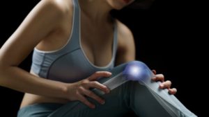 woman holding her knee with pain highlight