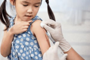 little girl getting a shot of vaccine