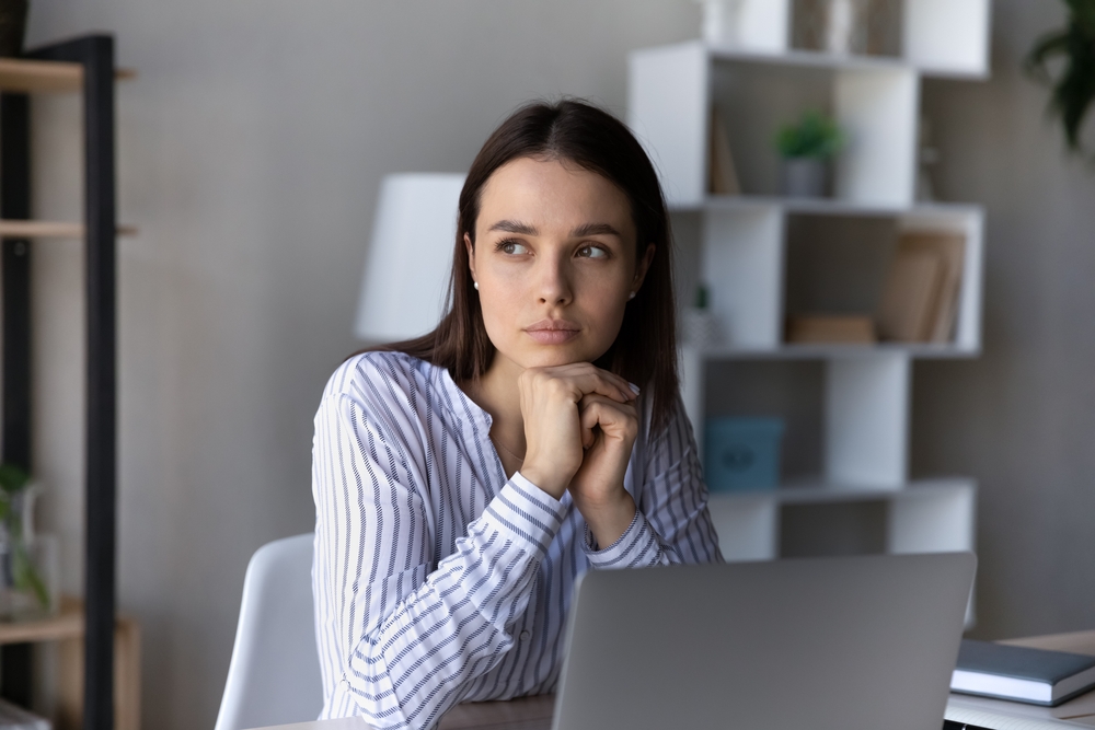 a person in front of a laptop thinking